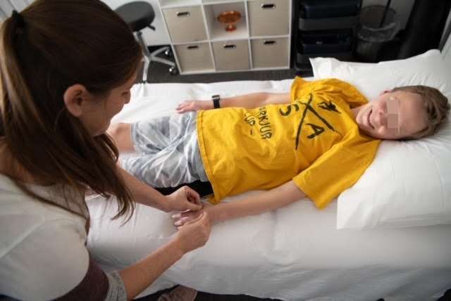 Acupuncturist treating a Child